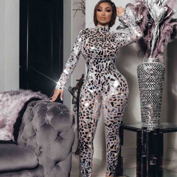 Rock both day and night vibes in our "Perfect Body Image Mirroring Sequin Stretchy Jumpsuit." Built on a sassy nude mesh backdrop and jazzed up with mirror-like sequins, this jumpsuit is your go-to for turning heads and making an entrance. With a high neckline and a fit that hugs you just right, you won't just fit in, you'll stand out. Oh, and don't sweat the small stuff—the back zipper makes getting into it a breeze. So go ahead, slip it on, and let the world see not just their reflection, but a glimpse of your fearless spirit too. When you catch your reflection, expect to see someone who's all kinds of fabulous!