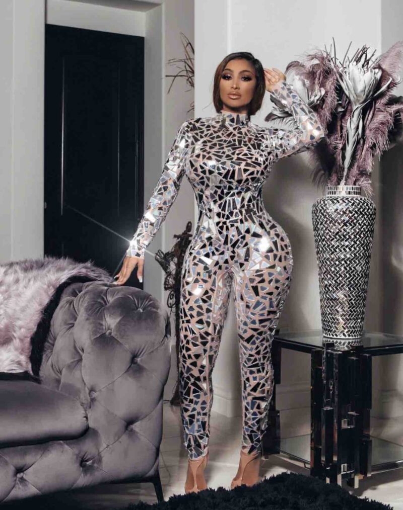 Rock both day and night vibes in our "Perfect Body Image Mirroring Sequin Stretchy Jumpsuit." Built on a sassy nude mesh backdrop and jazzed up with mirror-like sequins, this jumpsuit is your go-to for turning heads and making an entrance. With a high neckline and a fit that hugs you just right, you won't just fit in, you'll stand out. Oh, and don't sweat the small stuff—the back zipper makes getting into it a breeze. So go ahead, slip it on, and let the world see not just their reflection, but a glimpse of your fearless spirit too. When you catch your reflection, expect to see someone who's all kinds of fabulous!